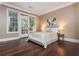 Cozy main bedroom with dark wood floors, neutral walls, and access to the outdoors at 3280 Stillhouse Se Ln # 108, Atlanta, GA 30339