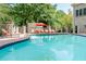 Inviting community pool area with lounge chairs, shade umbrellas, and mature trees at 3280 Stillhouse Se Ln # 108, Atlanta, GA 30339