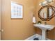 Stylish powder room with pedestal sink, designer mirror, and contemporary lighting creating a modern aesthetic at 3280 Stillhouse Se Ln # 108, Atlanta, GA 30339