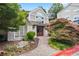 Beautiful building exterior with well-manicured landscaping, stone walkway, and inviting entryway with double wooden doors at 4248 River Green Nw Dr # 310, Atlanta, GA 30327