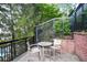 Outdoor patio featuring metal railing, round table and seating, with brick accent wall and mature landscaping at 4248 River Green Nw Dr # 310, Atlanta, GA 30327