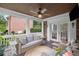 Relaxing back porch with comfortable wicker furniture, ceiling fan, and wooded view at 7615 Laurel Oak Dr, Suwanee, GA 30024