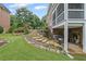 Landscaped backyard featuring stone steps, lush greenery, and a covered patio area at 7615 Laurel Oak Dr, Suwanee, GA 30024