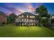 Evening view of the home showcasing the deck, patio, and expansive backyard at 7615 Laurel Oak Dr, Suwanee, GA 30024