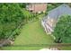 Expansive backyard with lush green lawn, a soccer net, and stairs leading to the home's deck and screened porch at 7615 Laurel Oak Dr, Suwanee, GA 30024