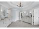 Spacious bathroom with dual vanities featuring white cabinets, marble countertops, and a tile floor at 7615 Laurel Oak Dr, Suwanee, GA 30024