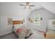 Airy bedroom with neutral colors, a sloped ceiling, a large window, and comfortable furnishings at 7615 Laurel Oak Dr, Suwanee, GA 30024