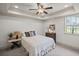 Comfortable bedroom with a soft bed, side table, and ample natural light at 7615 Laurel Oak Dr, Suwanee, GA 30024