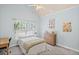 Bright bedroom with light blue walls, a window with a green view, and a cozy bed at 7615 Laurel Oak Dr, Suwanee, GA 30024