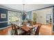 Dining room featuring a table set for dinner with a chandelier and blue painted walls at 7615 Laurel Oak Dr, Suwanee, GA 30024