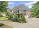 Beautifully landscaped home with mature trees and bushes with a driveway and three car garage at 7615 Laurel Oak Dr, Suwanee, GA 30024