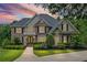 Charming two-story home illuminated by a sunset, featuring manicured landscaping, and a welcoming front entrance at 7615 Laurel Oak Dr, Suwanee, GA 30024