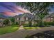 Charming two-story home illuminated by a sunset, featuring mature trees, and a welcoming front entrance at 7615 Laurel Oak Dr, Suwanee, GA 30024