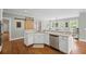 Bright kitchen features white cabinets, stainless steel appliances and unique sliding barn door detail at 7615 Laurel Oak Dr, Suwanee, GA 30024