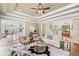 Open living room with fireplace, tray ceiling, and seamless flow to the kitchen and staircase at 7615 Laurel Oak Dr, Suwanee, GA 30024