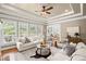 Spacious living room featuring large windows, hardwood floors, fireplace and comfortable neutral seating at 7615 Laurel Oak Dr, Suwanee, GA 30024