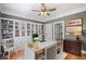 Well-organized office with built-in bookcase, white desk, wood floors, and stylish decor at 7615 Laurel Oak Dr, Suwanee, GA 30024