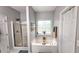 Bright bathroom features a tub with window view, glass-enclosed shower and white painted doors at 1245 Cedar Oak Ln, Lawrenceville, GA 30043