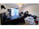 Bedroom with fan, window with blue curtains, bed, sofa, black dresser, and decor at 1245 Cedar Oak Ln, Lawrenceville, GA 30043