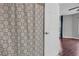 Bathroom with patterned shower curtain and open doorway to room with dark wood floor and gray walls at 1250 Parkwood Se Cir # 1213, Atlanta, GA 30339