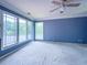 Bedroom features large windows with serene lake views, a ceiling fan, and plush carpeting at 3836 Loch Highland Ne Pkwy, Roswell, GA 30075