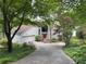 Inviting home featuring a red front door, two car garage and mature trees enhancing the curb appeal at 3836 Loch Highland Ne Pkwy, Roswell, GA 30075