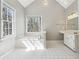 Bright main bathroom with soaking tub, tiled floor, double windows, and a vanity for a relaxing and convenient experience at 4271 Weston Sw Dr, Lilburn, GA 30047