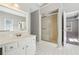 Bright bathroom with tiled flooring, white cabinets, a mirror, glass-enclosed shower and access to an adjoining bedroom at 4271 Weston Sw Dr, Lilburn, GA 30047