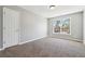 Standard-sized bedroom features neutral paint, carpeting, a window, and a closet space for comfortable living at 4271 Weston Sw Dr, Lilburn, GA 30047