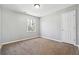 Small bedroom with light gray paint, carpeting, a double door closet, and a window for natural light and ventilation at 4271 Weston Sw Dr, Lilburn, GA 30047