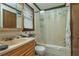 Bathroom features a tub with shower, toilet, and sink with a wood cabinet at 4800 Silverberry Nw Ln, Acworth, GA 30102