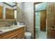 Bathroom with floral wallpaper, sink with vanity, toilet, and doorway to a shower at 4800 Silverberry Nw Ln, Acworth, GA 30102