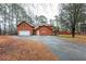 Rustic wood-sided home with an attached two-car garage, mature trees, driveway, and a storage shed at 4800 Silverberry Nw Ln, Acworth, GA 30102