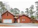 Rustic wood-sided home with an attached two-car garage, mature trees, and driveway at 4800 Silverberry Nw Ln, Acworth, GA 30102