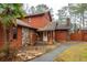 Charming wood home featuring stone accents, a stone chimney, a front porch with swing and mature trees at 4800 Silverberry Nw Ln, Acworth, GA 30102