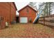 Garage with a white door and outdoor storage, set against a backdrop of trees and greenery at 4800 Silverberry Nw Ln, Acworth, GA 30102