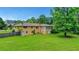 A vast backyard features lush green grass and mature trees surrounding the property at 3332 Oak Grove Rd, Loganville, GA 30052