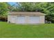 Detached two-car garage with two white garage doors, offering ample parking and storage space at 3332 Oak Grove Rd, Loganville, GA 30052