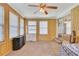 Bright sun room with wood paneled walls, lots of windows and a ceiling fan at 3332 Oak Grove Rd, Loganville, GA 30052