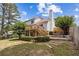 Exterior view of back of home with deck and stairs, a lush green yard, and blue skies at 11100 Chandon Way, Johns Creek, GA 30097