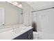 Bathroom with navy vanity, white countertop, modern mirror, and shower with tile surround at 11100 Chandon Way, Johns Creek, GA 30097