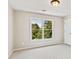 Cozy bedroom featuring a neutral color palette, window with green view, and standard closet at 11100 Chandon Way, Johns Creek, GA 30097