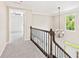 Upstairs hallway overlooking front entrance, features hardwood handrail with iron spindles and natural light at 11100 Chandon Way, Johns Creek, GA 30097