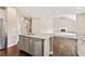 Spacious kitchen with stainless steel appliances and granite countertops overlooking the living room with fireplace at 11100 Chandon Way, Johns Creek, GA 30097