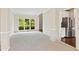 Open-concept living room with a large window letting in natural light, and neutral-colored carpet at 11100 Chandon Way, Johns Creek, GA 30097
