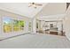 Spacious living room open to kitchen, with a ceiling fan and lots of natural light from large windows at 11100 Chandon Way, Johns Creek, GA 30097