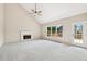 Spacious living room featuring vaulted ceilings, a fireplace, carpet, and a door leading to the outdoor deck at 11100 Chandon Way, Johns Creek, GA 30097