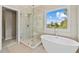 Spa-like main bathroom featuring a glass-enclosed shower, soaking tub, and walk-in closet at 11100 Chandon Way, Johns Creek, GA 30097