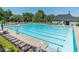 Large swimming pool with lounge chairs, umbrellas and a lifeguard stand on a sunny day at 11100 Chandon Way, Johns Creek, GA 30097