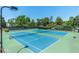 Multiple tennis courts with green and blue surfaces, nets, and surrounded by trees at 11100 Chandon Way, Johns Creek, GA 30097